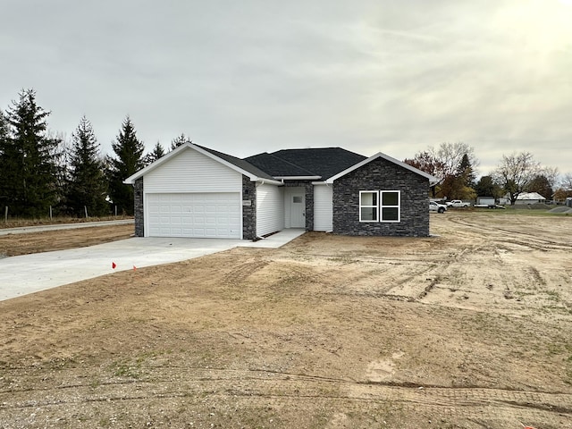 view of front of house with a garage, concrete driveway, and stone siding