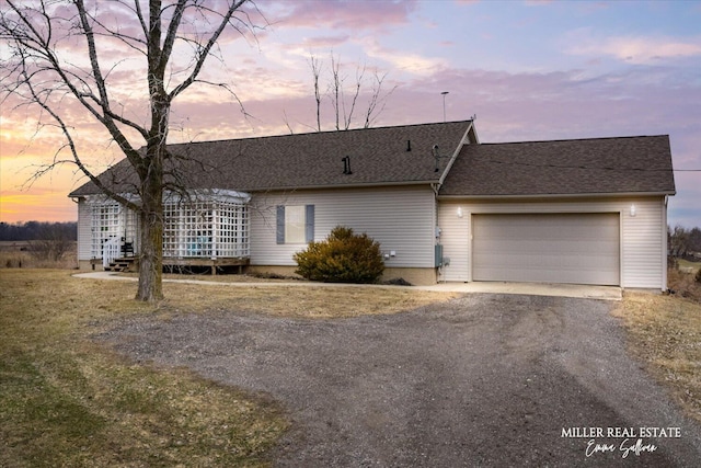 view of front of property with driveway, an attached garage, and a shingled roof