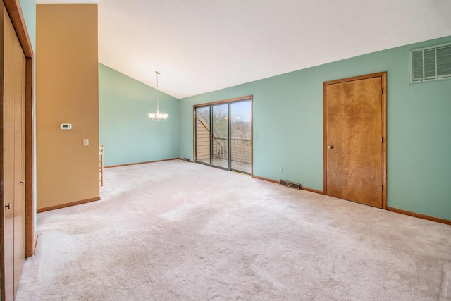 carpeted spare room featuring lofted ceiling, baseboards, visible vents, and an inviting chandelier