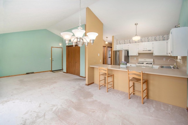 kitchen with white range with gas stovetop, lofted ceiling, freestanding refrigerator, under cabinet range hood, and a sink