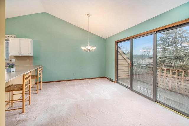 unfurnished dining area with lofted ceiling, light carpet, baseboards, and a notable chandelier