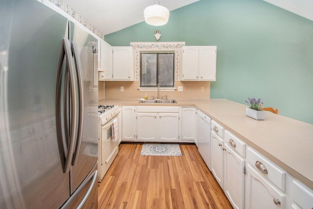 kitchen featuring lofted ceiling, white appliances, a sink, white cabinets, and light wood-type flooring