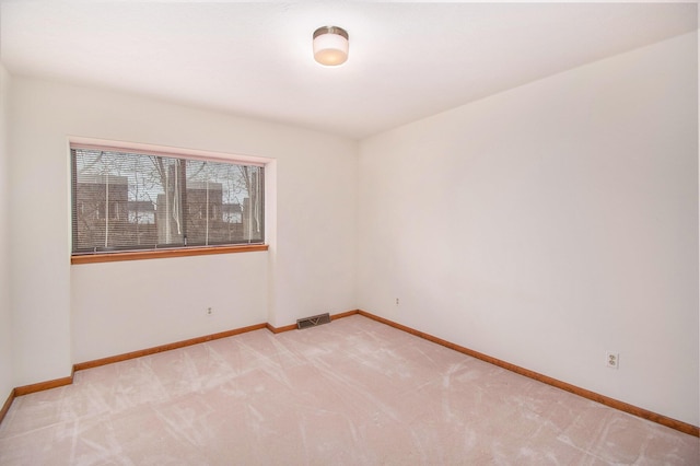 unfurnished room featuring light colored carpet, visible vents, and baseboards