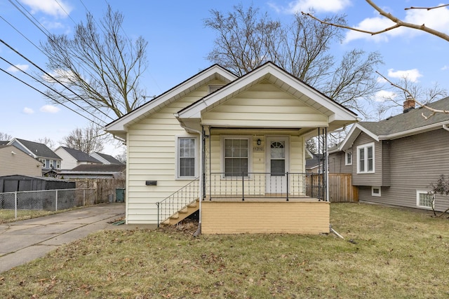 bungalow featuring a porch, a front yard, and fence