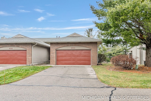 view of front of property with a garage, driveway, brick siding, and roof with shingles