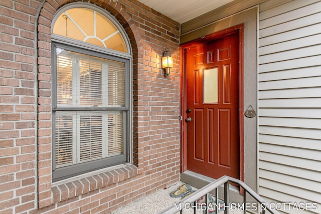 doorway to property with brick siding