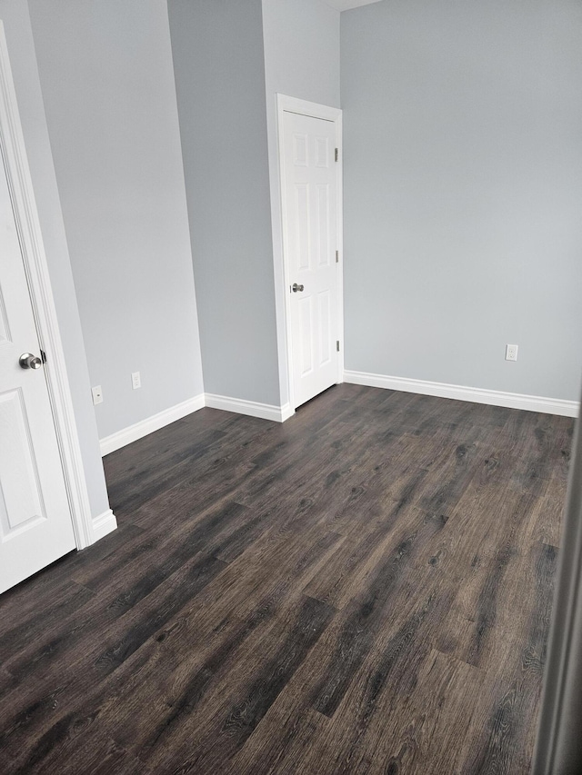 unfurnished room featuring dark wood-style flooring and baseboards