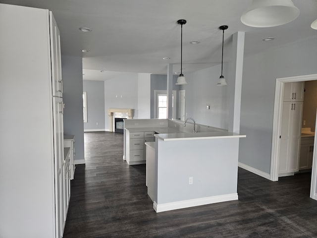 kitchen featuring dark wood-type flooring, open floor plan, and baseboards