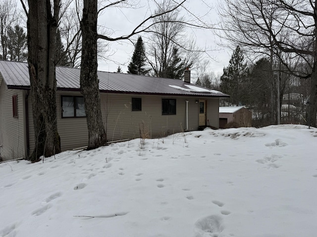 view of front of property with metal roof and a chimney