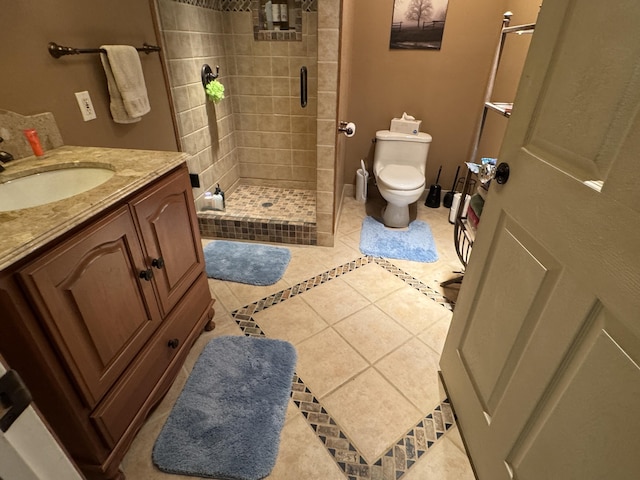 full bathroom with a stall shower, vanity, toilet, and tile patterned floors