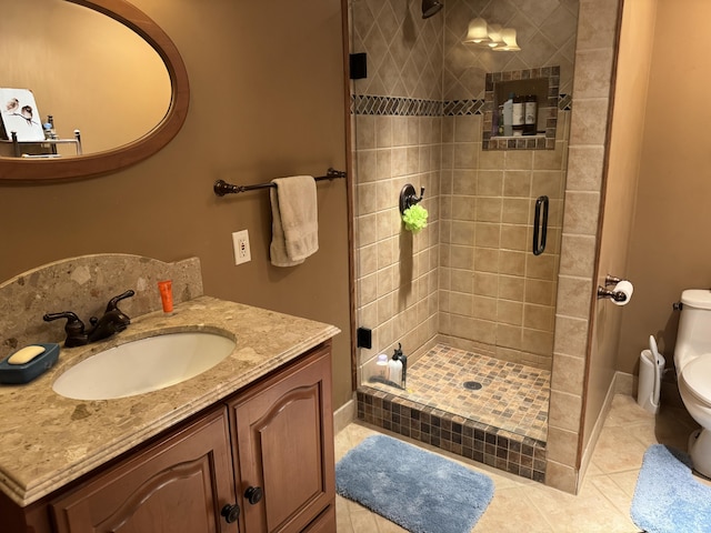 bathroom featuring baseboards, toilet, tile patterned floors, vanity, and a shower stall