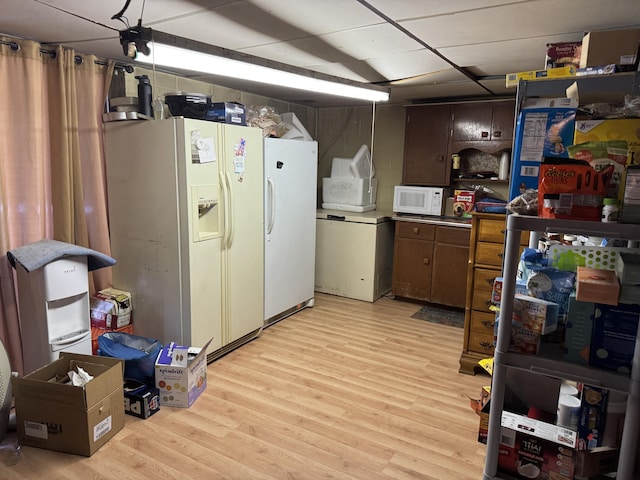 kitchen featuring light wood-type flooring and white appliances