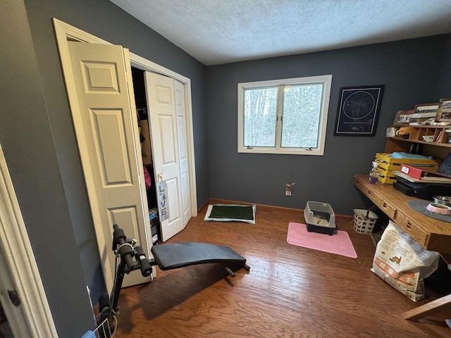 interior space with a textured ceiling and wood finished floors