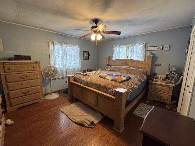 bedroom featuring a textured ceiling, wood finished floors, a ceiling fan, and crown molding