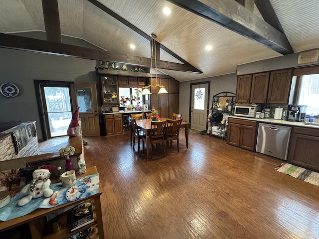 kitchen with dark wood-style floors, vaulted ceiling with beams, light countertops, white microwave, and dishwasher