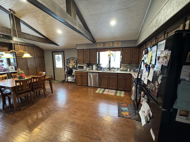 kitchen featuring white microwave, freestanding refrigerator, light countertops, stainless steel dishwasher, and beam ceiling