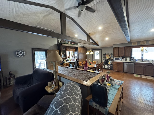 kitchen featuring pendant lighting, stainless steel appliances, light countertops, lofted ceiling with beams, and wood finished floors