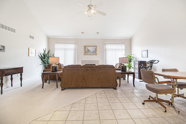 living area featuring light tile patterned floors, visible vents, and light colored carpet