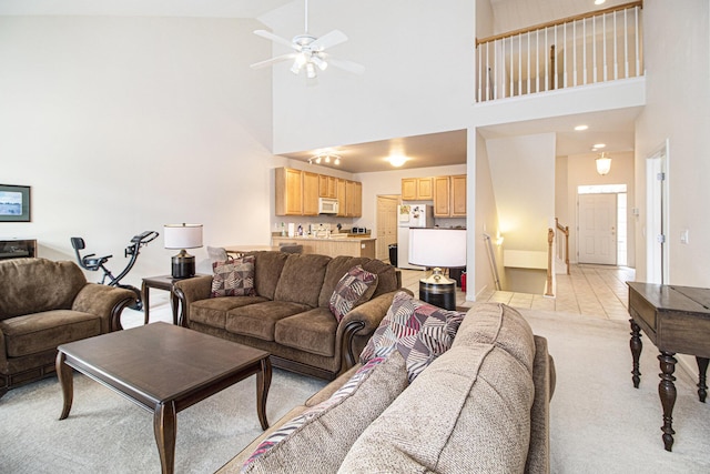 living area featuring light tile patterned flooring, a ceiling fan, and light colored carpet