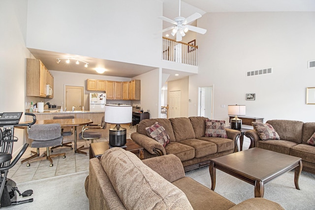 living room featuring lofted ceiling, visible vents, a ceiling fan, and light tile patterned flooring