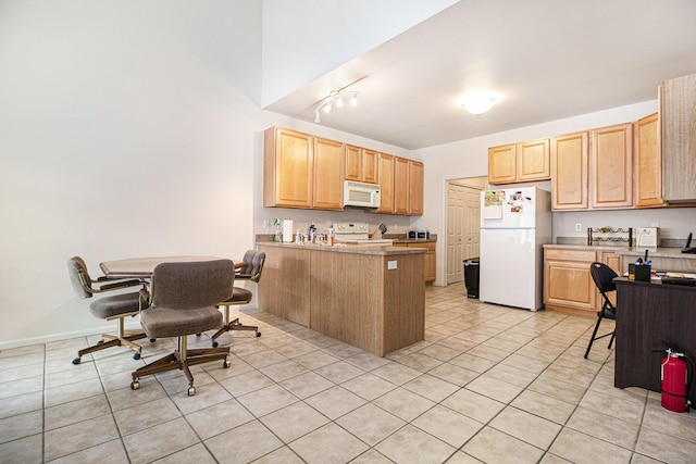 kitchen with a peninsula, white appliances, light tile patterned floors, and light brown cabinetry