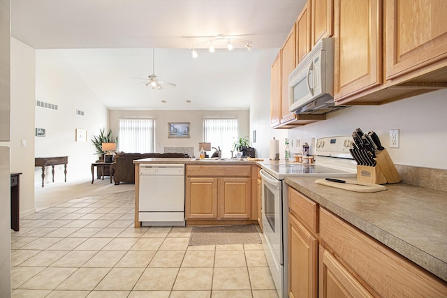 kitchen with white appliances, visible vents, vaulted ceiling, a sink, and light tile patterned flooring