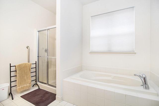 bathroom with a shower stall, a bath, and tile patterned floors