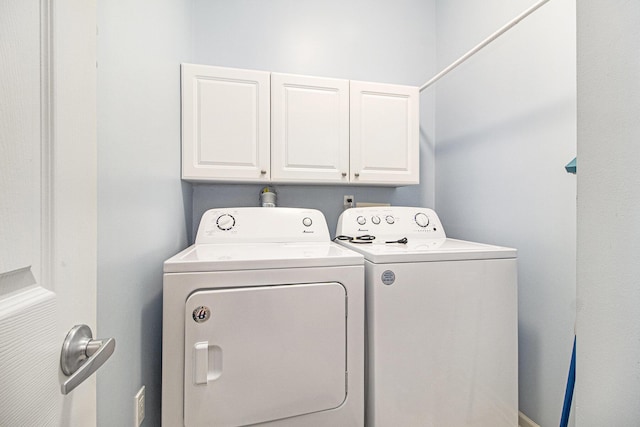 washroom with separate washer and dryer and cabinet space