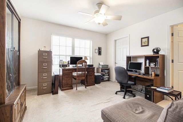 office space with baseboards, a ceiling fan, and light colored carpet