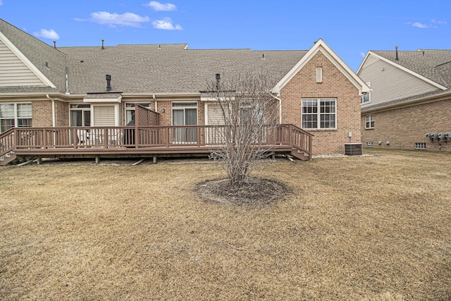 rear view of property with a wooden deck, roof with shingles, cooling unit, and brick siding