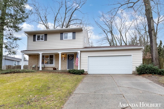 traditional home with a garage, a front yard, concrete driveway, and fence