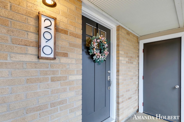 doorway to property featuring brick siding