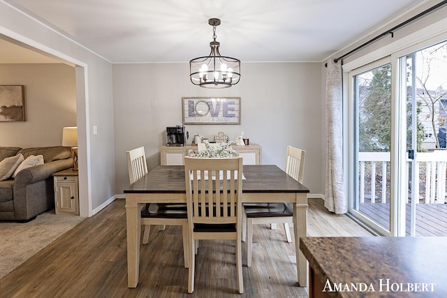 dining space featuring a notable chandelier, baseboards, and wood finished floors