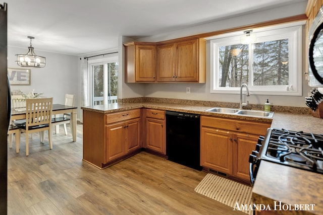 kitchen with light wood-style floors, brown cabinetry, dishwasher, and a sink