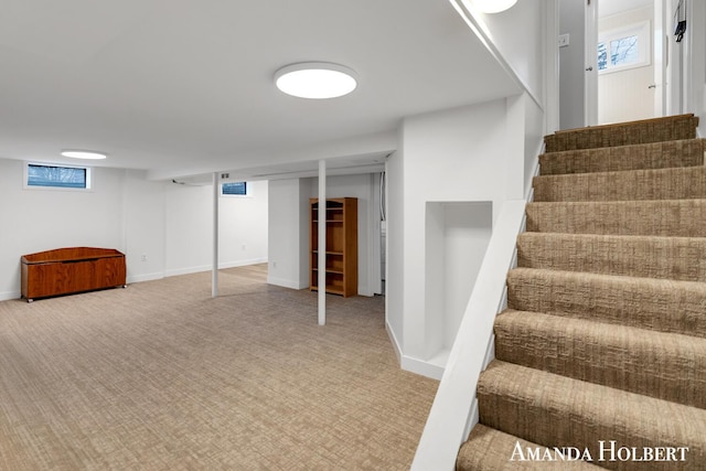 below grade area with carpet floors, baseboards, and stairs