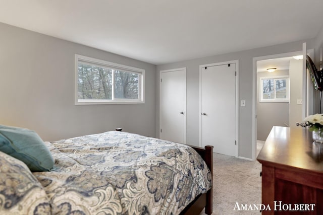 bedroom featuring multiple closets and carpet flooring