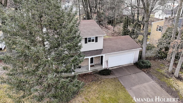 view of front of house featuring an attached garage, driveway, a shingled roof, and brick siding