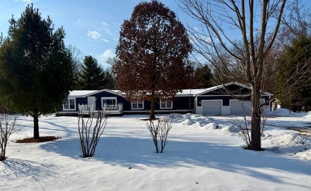 snow covered property with a garage