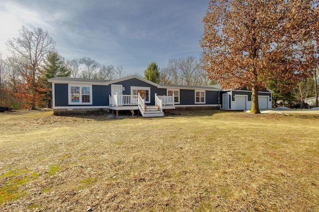 manufactured / mobile home featuring a wooden deck and a front lawn