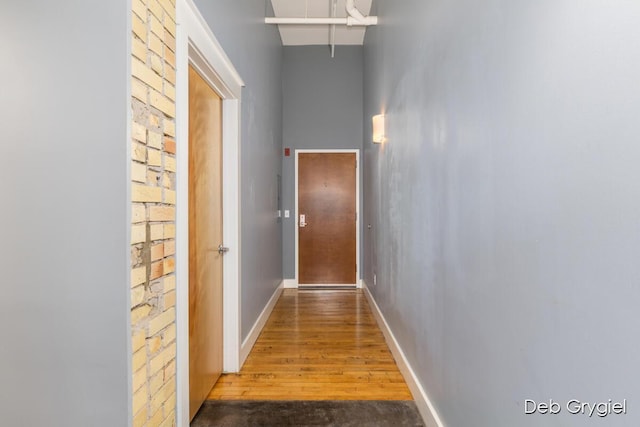 corridor with a towering ceiling and baseboards