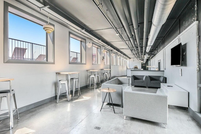 living room featuring concrete flooring and baseboards