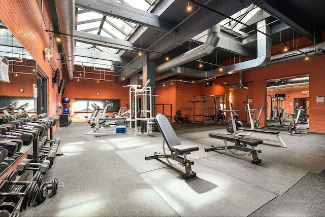 exercise room featuring a towering ceiling