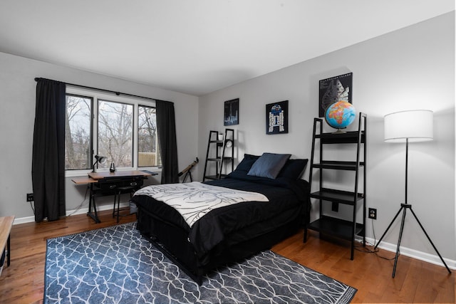 bedroom with wood finished floors and baseboards