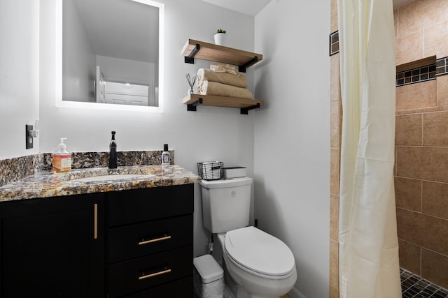 full bathroom with a tile shower, vanity, and toilet