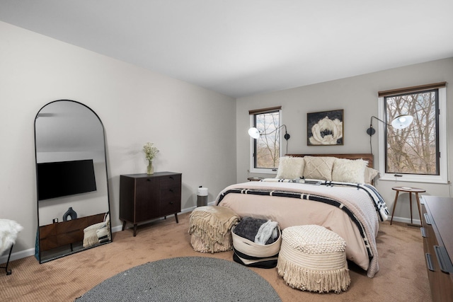 bedroom with light colored carpet and baseboards