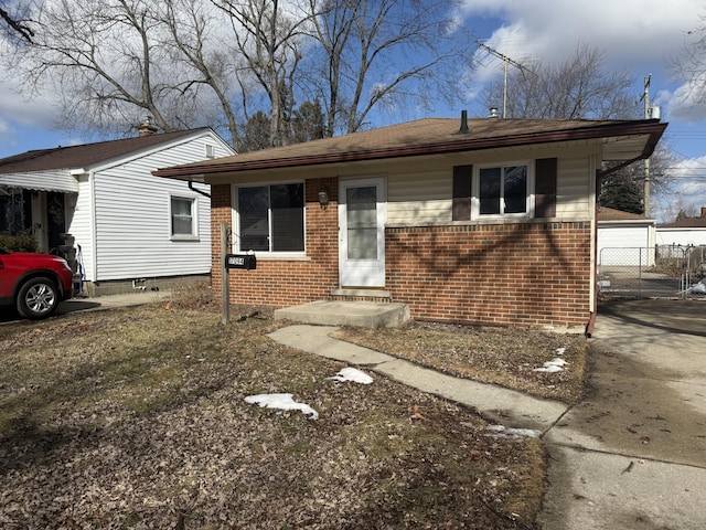 view of front facade with a garage, brick siding, and fence