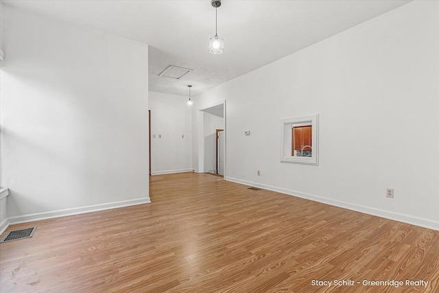 unfurnished room with light wood-style flooring, visible vents, and baseboards