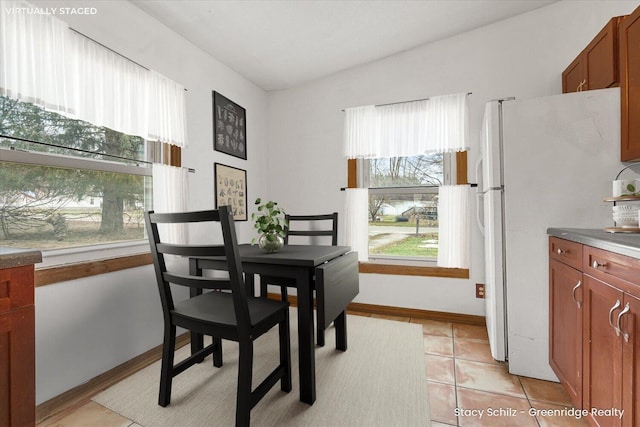 dining area with vaulted ceiling and light tile patterned flooring