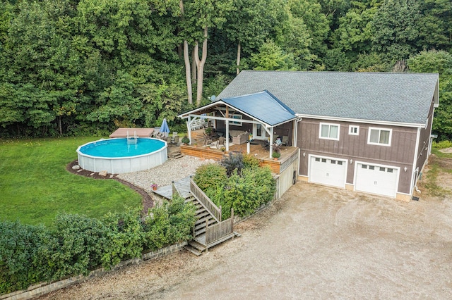 pool with a deck, a lawn, and stairs