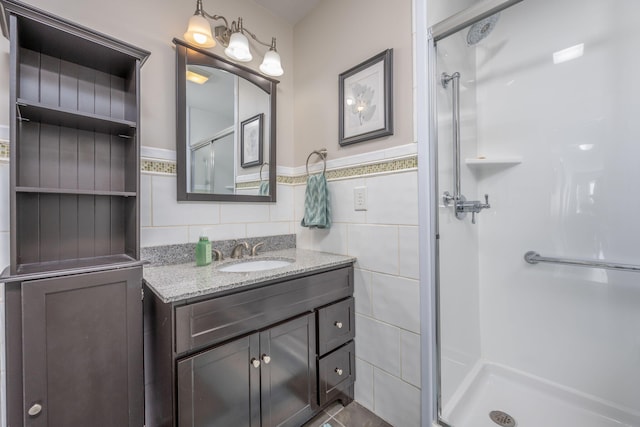 8581 Lynwood Ln, Mecosta, MI 49332 - full bathroom featuring vanity, tile walls, wainscoting, and a stall shower